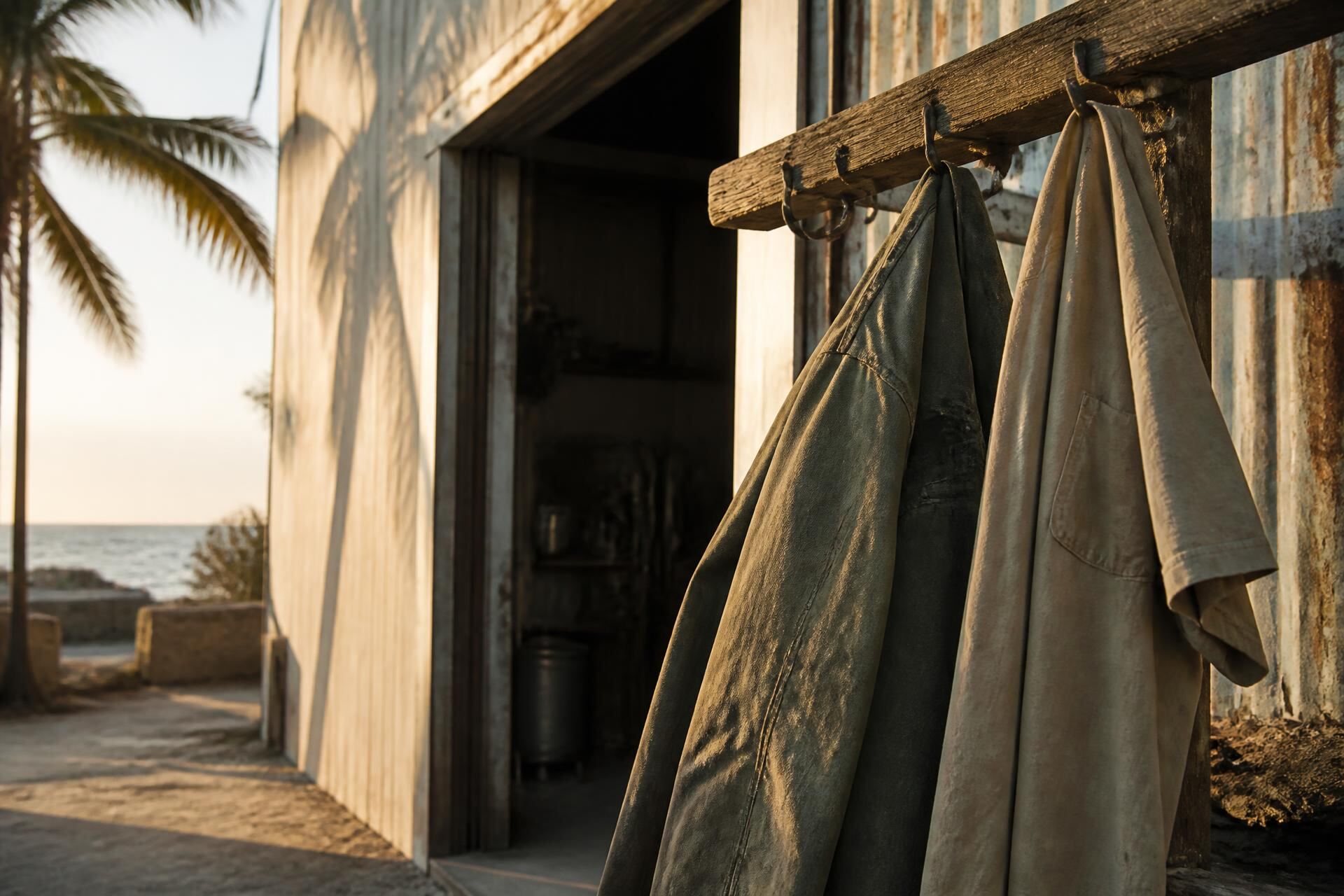 Canvas work jackets hanging outside a coastal Florida workshop at sunset